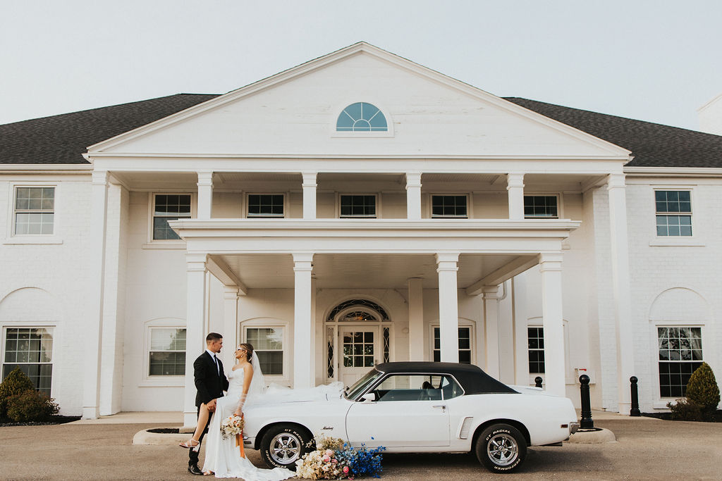couple poses with car in front of Westbrook Country Club