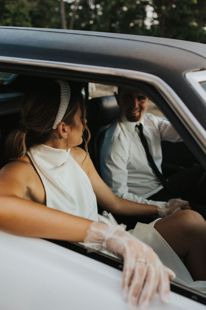couple pose in classic car