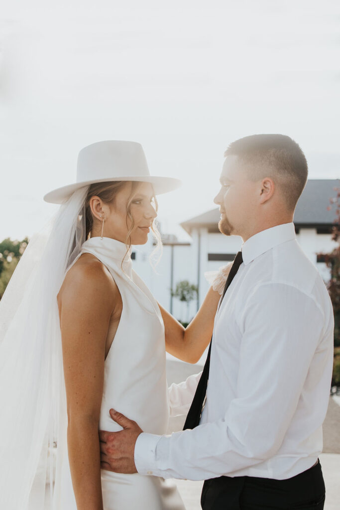couple poses in front of Westbrook Country club during sunset