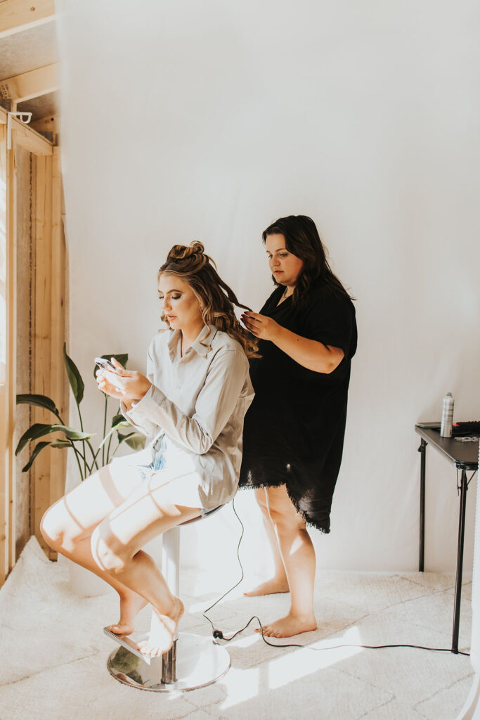 bride getting hair done in bridal suite